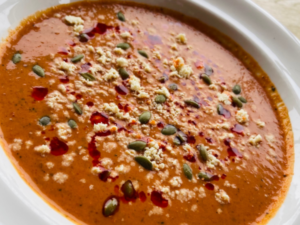 Roasted Red Pepper soup topped with Mandala Chili Crisp, Vegan Feta, and pumpkin seeds.